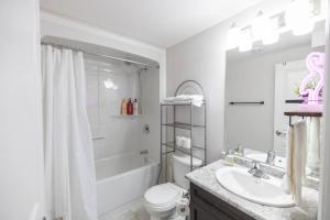 uma casa de banho branca com um chuveiro e um lavatório. em 8 BEDS Tomorrowland - 15 Minutes To The Falls em Thorold