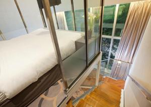 Pokój z łóżkiem i szklaną ścianą w obiekcie Dorsett Singapore w Singapurze