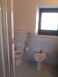 a bathroom with a toilet and a sink at 1st floor apartment in villa Falari near the in Avola
