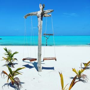 ein Holzkreuz am Strand mit Schaukel in der Unterkunft Gaafaru View Inn in Gaafaru