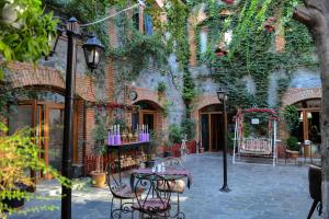 a patio with tables and chairs in front of a building at Old Town Sheki in Sheki