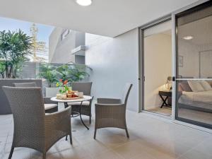 a balcony with a table and chairs and a bedroom at Riptide on Surf Beach in Kiama +16 photos