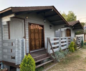 a small white house with a porch and a door at Домики у Лизы под ключ in Pizunda