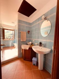 a blue tiled bathroom with a sink and a shower at Da Nonna Pasqualina in Ciorlano