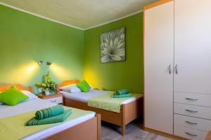 1 grünes Schlafzimmer mit 2 Betten und einem Schrank in der Unterkunft Rooms Edna in Dubrovnik