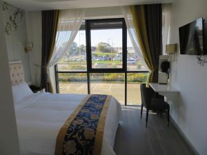 um quarto de hotel com uma cama, uma secretária e uma janela em KYRIAD ROUEN SUD - Sotteville les Rouen em Rouen