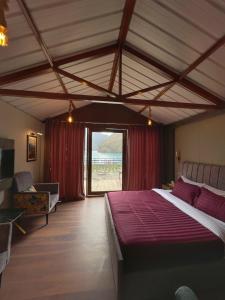 Un dormitorio con una cama grande y una ventana grande. en Horizon Resort Attabad Lake Hunza, en Hunza