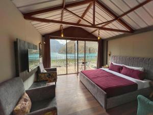 Un dormitorio con una cama grande y una ventana grande. en Horizon Resort Attabad Lake Hunza, en Hunza