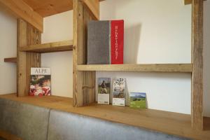 a book shelf with two books on it at Schartnerhof Ferienwohnung Salbei in Vols am Schlern
