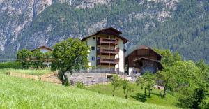 a building on the side of a hill with a mountain at Schartnerhof Ferienwohnung Thymian in Vols am Schlern