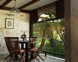 a dining room table with a wooden table and chairs at Alindra Villa in Nusa Dua