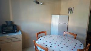 une cuisine avec une table et un réfrigérateur blanc dans l'établissement Résidence Eterle, à Luz-Saint-Sauveur 7 autres photos
