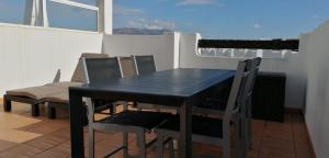 y balcón con mesa de comedor negra y sillas. en Apartment N510, Naranjos 6, Condado De Alhama, en Alhama de Murcia
