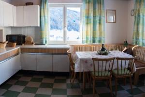 kuchnia ze stołem i krzesłami oraz oknem w obiekcie 10Bedroom House Obertauern-Salzburg for 30 people w mieście Radstadt