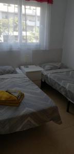 een slaapkamer met 2 bedden, een raam en een wastafel bij Apartment N510, Naranjos 6, Condado De Alhama in Alhama de Murcia