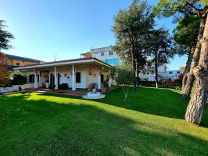 une maison dotée d'une cour avec de l'herbe verte et des arbres dans l'établissement Vitti's Home Verona, à Vérone