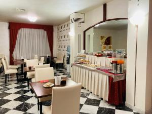 un ristorante con tavolo, sedie e buffet di Hotel Master ad Albignasego