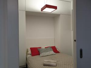 a small bedroom with a bed with a light above it at Apartamenty Promenada in Warsaw