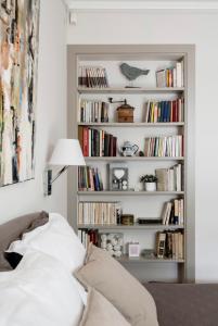 ein Bücherregal gefüllt mit Büchern in einem Schlafzimmer in der Unterkunft 1 Square du Docteur Blanche - Paris 16 in Paris