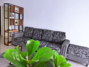 a living room with a couch and a plant at Traveler's homestay 旅人窝@ The Venus Sitiawan in Kampong Lumut Kiri