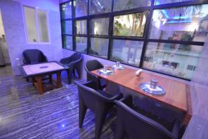 a restaurant with a table and chairs and windows at Aryan residency in Māvalli