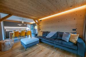 een woonkamer met een blauwe bank en een tafel bij Besseghini Apartments in Livigno