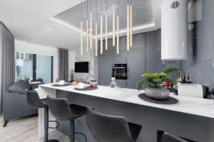 uma cozinha e sala de estar com uma grande ilha com cadeiras em Mogilska Apartments by Renters Prestige em Cracóvia