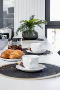 un tavolo con due tazze di tè e croissant di Mogilska Apartments by Renters Prestige a Cracovia