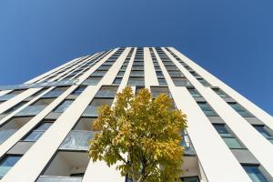 Un edificio alto con un albero davanti di Mogilska Apartments by Renters Prestige a Cracovia