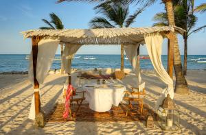 a table and chairs under a canopy on the beach at Billionaire Resort & Retreat Malindi in Malindi