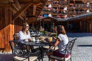 Dos mujeres sentadas en una mesa en un restaurante en La Cordée des Alpes SUP, en Verbier