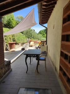 una mesa y una silla en el patio en Podere Buonarosa en Camaiore
