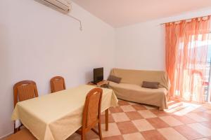 a room with a table and chairs and a couch at Apartments Zdravko in Klek