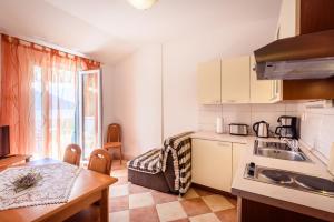une petite cuisine avec un évier et une table dans l'établissement Apartments Zdravko, à Klek