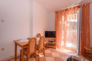 a dining room with a table and chairs and a television at Apartments Zdravko in Klek +66 photos