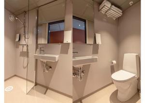 een badkamer met 2 wastafels en een toilet bij Hotell Arendal in Arendal