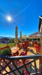 a patio with tables and chairs and umbrellas at Vila Breg Zlatibor in Zlatibor
