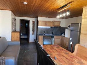 オトリュスにあるGrand appartement aux SAISIESのキッチン(テーブル、ソファ、冷蔵庫付)