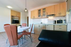a kitchen with a table and chairs in a kitchen at Apartments Branimir in Murter