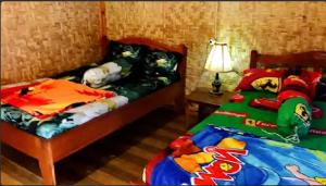 a bedroom with two beds with hello kitty pillows at Ijen Miner Family Homestay in Banyuwangi +22 photos