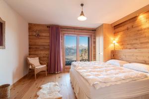 Un dormitorio con una cama grande y una ventana en Hirondelle JACUZZI & LUXURY chalet 12 pers by Alpvision Résidences en Veysonnaz