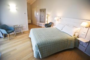 1 dormitorio con 1 cama, mesa y sillas en Il Fienile, en Fagagna