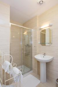 a bathroom with a sink and a glass shower at Glencourt Apartments in Dublin