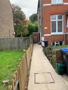 a sidewalk in a yard next to a house at Cozy 1 Bedroom Basement Flat in London