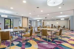 a conference room with tables and chairs on a colorful rug at The Leo Collection Detroit, Ascend Hotel Collection in Lincoln Park