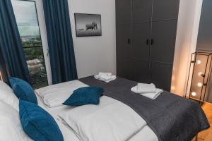 una camera da letto con un grande letto con cuscini blu di Amazing view over Vienna and infinity pool a Vienna
