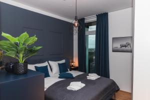 una camera da letto con un letto con pareti blu e una pianta di Amazing view over Vienna and infinity pool a Vienna