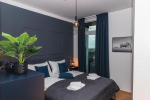 a bedroom with a bed with blue walls and a plant at Great apartment with view and heated rooftop Pool in Vienna +72 photos