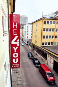 een bord aan de zijkant van een gebouw met geparkeerde auto's bij THE 4YOU Hostel & Hotel Munich in München