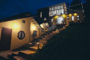 a house with stairs leading up to it at night at Hagiang-holic in Dồng Văn